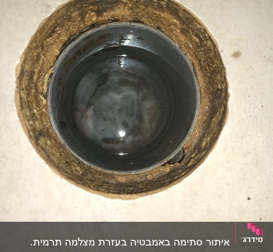 צינור פלסטיק עגול בתוך קיר עם סימני רטיבות